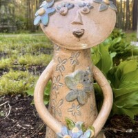tan abstract sculptural shape of a figure decorated in flowers