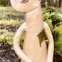 tan abstract sculptural shape of a figure decorated in leaves