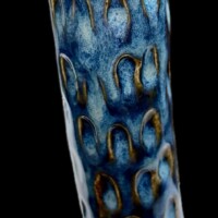 deep sea colored ceramic tube shape vessel with small oval cutaways