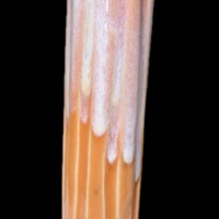 orange and white vessel with carved cutaways