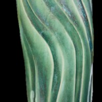 green vessel with carved wavy cutaway